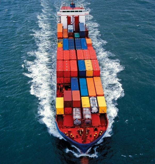 photo of container cargo ship at sea caring hundreds of containers that are various colors
